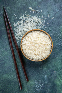 top view raw rice with sticks inside plate dark desk